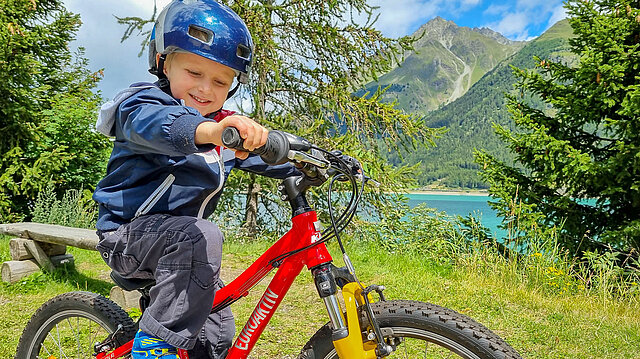 Kleinkind auf rotem Fahrrad