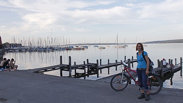 Frau mit Fahrrad vor See