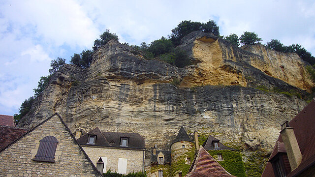 Felswand hinter einem kleinen Dorf