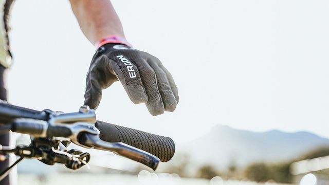 Hand mit Handschuh am Lenker