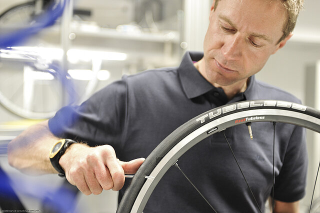 Ein Mann bringt Tubeless-Reifen an.